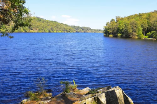 Vue pittoresque du lac avec rive rocheuse et forêts verdoyantes à l'Hôtel De La Vallée, Saint-Gilles-Vieux-Marché