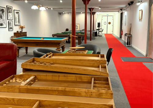 Salle de jeux au Domaine Les Racines avec tables de billard, table de pool et piste de bowling rouge