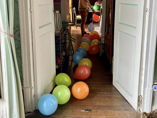 Ballons colorés alignés dans le couloir de la boutique-hôtel Château de Vaux Morvan à Étang sur Arroux, France