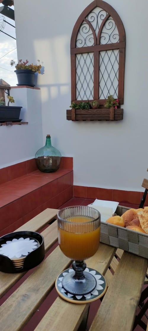 Desayuno en Mirador Medieval con zumo de naranja, cesta de pan y arquitectura española tradicional