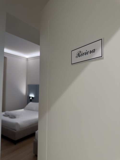 Ingresso della camera Riviera presso la Maison Riviera BnB di Reggio di Calabria con arredamento moderno e letto visibile