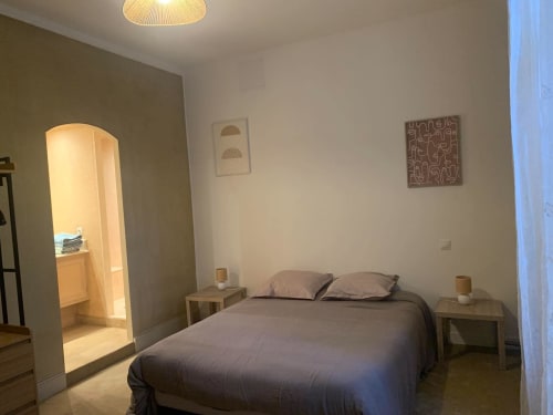 Chambre moderne à Mi Casa Es Su Casa à Carcassonne avec lit, tables de nuit et art mural contemporain
