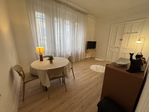 Spacieux séjour de l'appartement Le Cocon Urbain à Carcassonne, avec coin repas, TV et vue sur la ville
