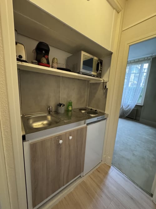 Kitchenette compacte dans l'appartement Le Cocon Urbain, hôtel de Carcassonne, avec évier, cuisinière et rangements