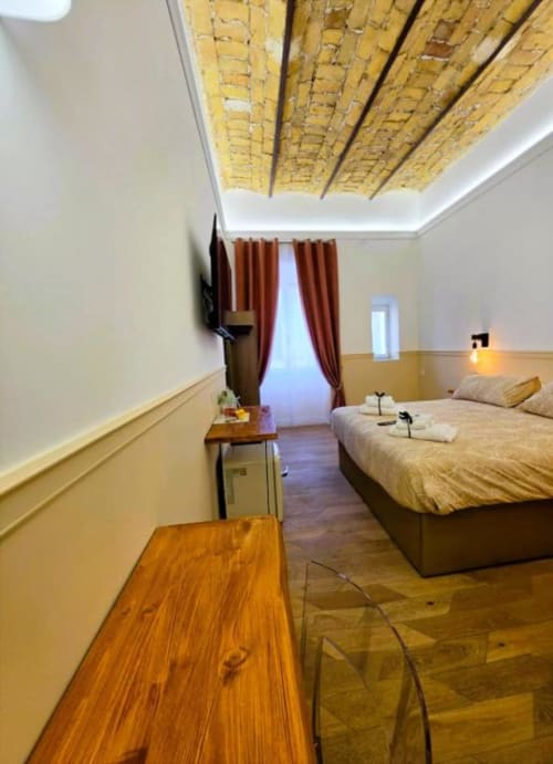 Camera tripla di lusso a Vatican Nice Holiday a Roma con pavimentazione in legno, soffitto in legno a vista, letti gemelli e rosso