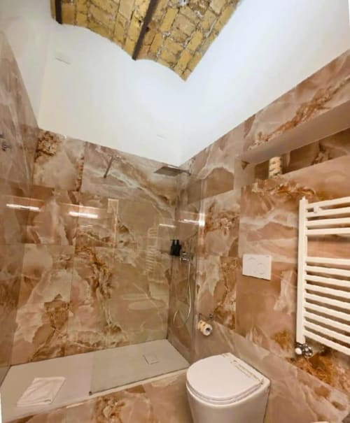 Bagno moderno con piastrelle in marmo, doccia walk-in, wc, portasciugamani bianco e lucernario - Luxury Vatican Nice Holiday