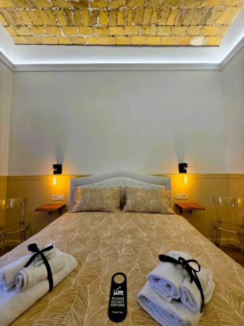 Camera Superior con Letto Queen al Vatican Nice Holiday Luxury Rooms di Roma con asciugamani di benvenuto, comodini doppi e piastrelle gialle