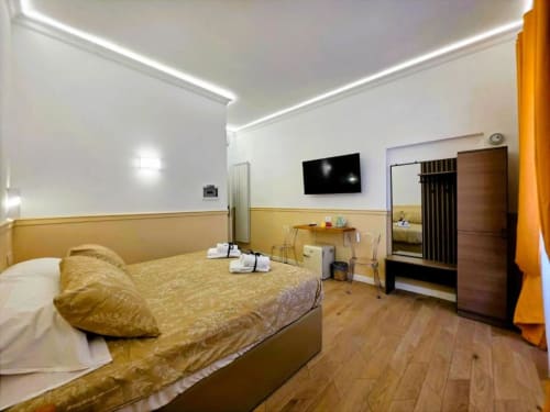 Camera Tripla Superiore presso Vatican Nice Holiday Luxury Rooms a Roma con biancheria dorata, TV a schermo piatto e pavimento in legno