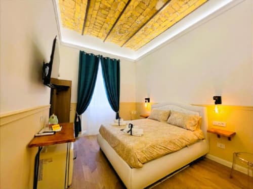 Lussuosa camera d'hotel al Vatican Nice Holiday con biancheria dorata, soffitto giallo e tende blu petrolio a Roma