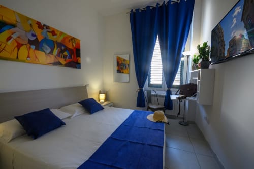 Blue and white bedroom at Dimore Salentine hotel in Lecce with city views, modern decor and desk