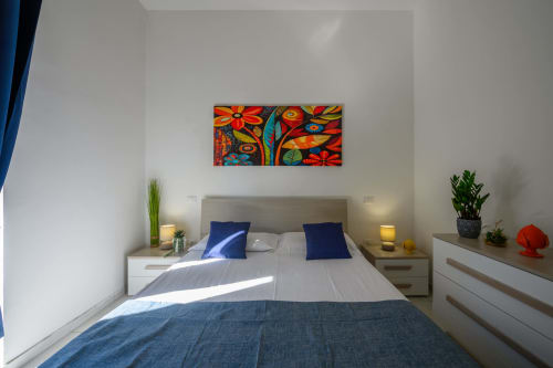 Modern bedroom at Dimore Salentine in Lecce with blue accents, colorful artwork, and city view