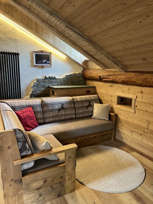 Suite in legno accogliente presso Residenza Verdebjo con divano a quadri, camino e vista sulle Alpi a Gressoney-Saint-Jean