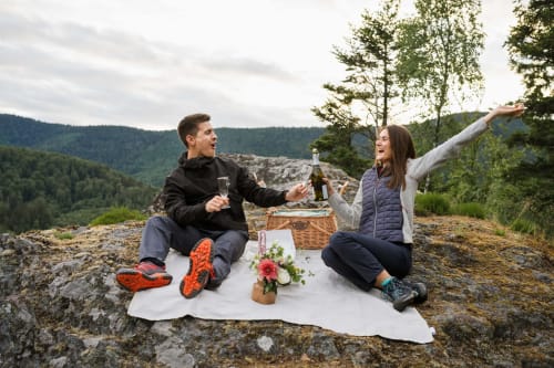 Couple dégustant du champagne en pique-nique avec vue panoramique près des Cabanes du Nideck, Oberhaslach