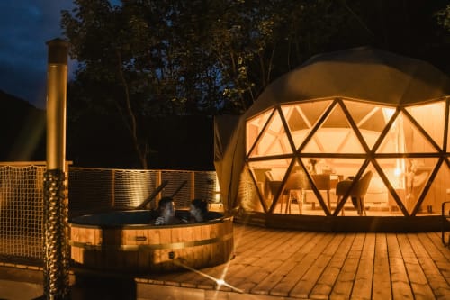 Des clients se détendent dans un bain à remous du dôme glamping Les Cabanes du Nideck, Oberhaslach, France