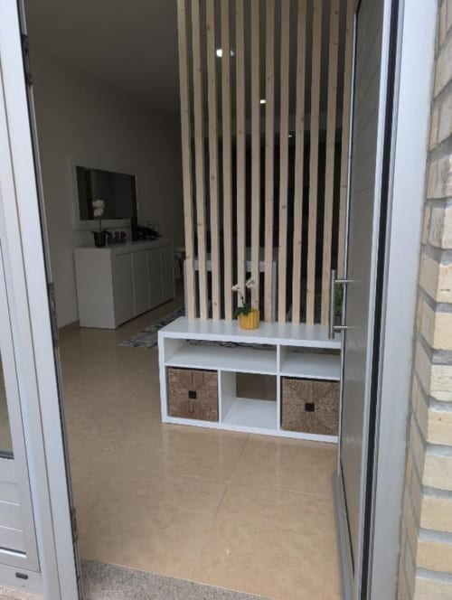 Sala de estar moderna no Apartamento Sol e Mar em Villas Eden com painel de armazenamento branco, divisória de madeira e TV de tela plana