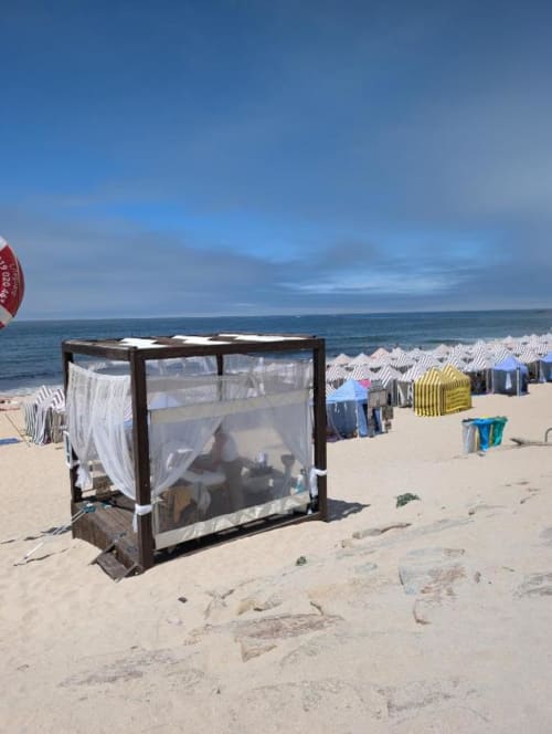 Cabanas de praia e tendas listradas para banho em Fão, resort costeiro português com vista para o oceano
