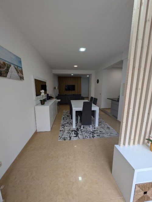 Interior moderno de apartamento em Villas Eden com mesa de jantar, cozinha e sala de estar com vista para o terraço em Fão