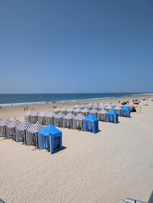 Praia de Fão, Portugal com cabanas listradas e tendas azuis ao longo da areia perto do hotel Villas Eden