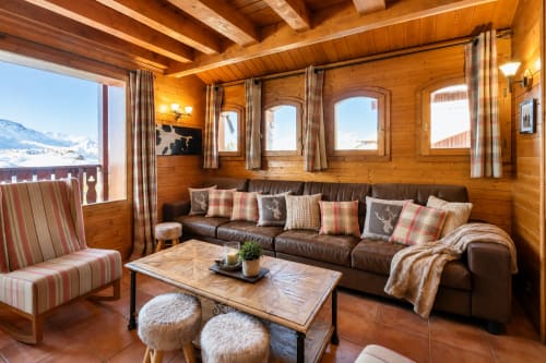 Salon chaleureux en bois avec vue sur les montagnes au Chalet du Vallon, Les Étoiles de la Plagne, canapé en cuir