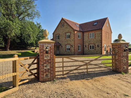 Villy Mansion cottage with brick chimney and wooden gates at Rose Vill Homes, Fakenham