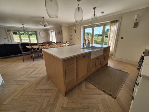 Modern open-plan kitchen and dining area in Villy Mansion cottage at Rose Vill Homes, Fakenham, with wooden island and garden