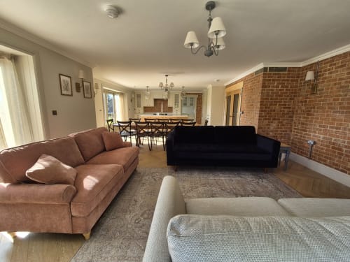Spacious open-plan living area at Villy Mansion cottage in Fakenham with multiple sofas, dining table, and kitchen visible