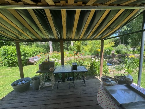 Terrasse ombragée avec pergola au Clos du Buisson BnB, vue sur le jardin, table à manger et aménagements paysagers à Saint Aubin sur