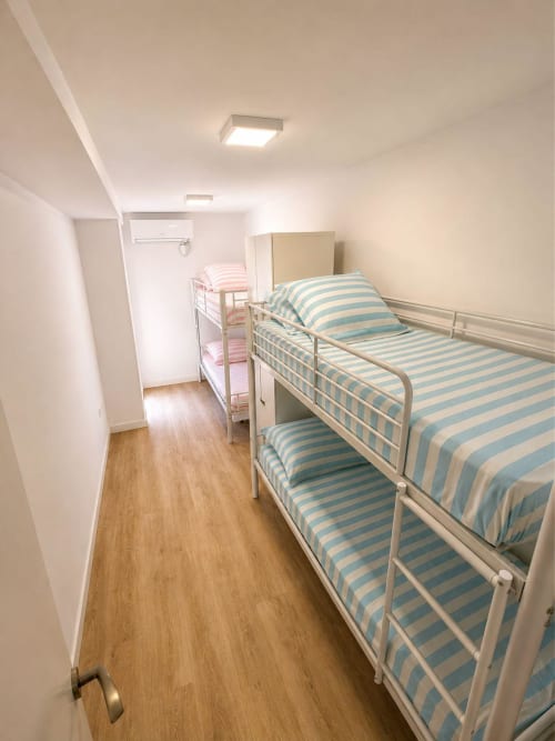 Dormitorio luminoso con camas literas de ropa de cama azul y blanca a rayas en ML Apartments cerca de la playa de Farnals, Picanya