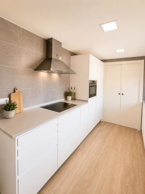 Cocina moderna en ML Apartments Picanya con gabinetes blancos, salpicadero de azulejos beige y campana extractora acero inoxidable