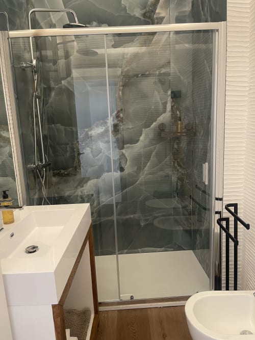 Modern bathroom with glass shower enclosure and white vanity sink at Like at Home Palau apartment, Palau