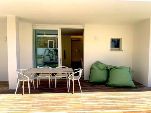 Modern ground floor apartment terrace at Like at Home Palau with dining table, green bean bags, and garden view in Palau,