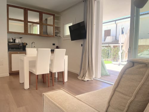 Modern apartment at Like at Home Palau with dining area, kitchenette, TV, and garden view through terrace doors