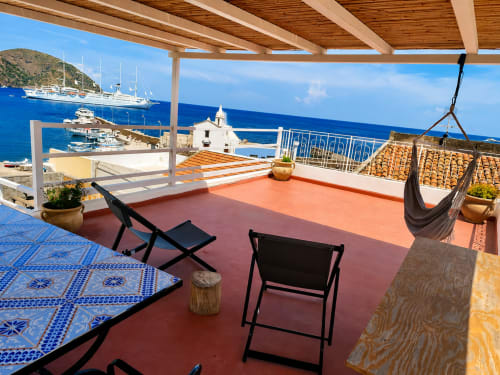 Terrazza di Casa Giuliana a Lipari con vista mare, lettini, amaca e barche