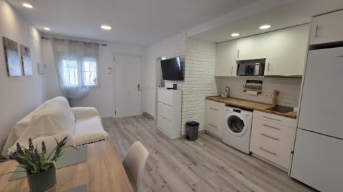 Pequeña cocina moderna con gabinetes blancos y encimera de madera en la casa rural MONICA SOCARICI, Benicàssim
