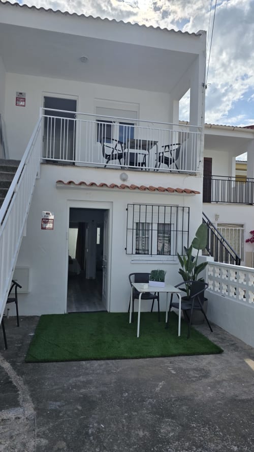 Casa Monica Socarici en Benicàssim con balcón blanco, patio amueblado, césped artificial y vista al jardín