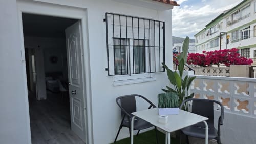 Terraza frente al mar del hotel Monica Socarici en Oropesa con asientos, maceta y flores magenta vibrantes