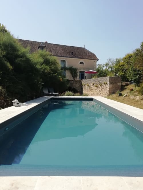 Piscine turquoise avec terrasse en pierre aux Chambres d'Hôtes au Moulin de la Croix, Charnizay