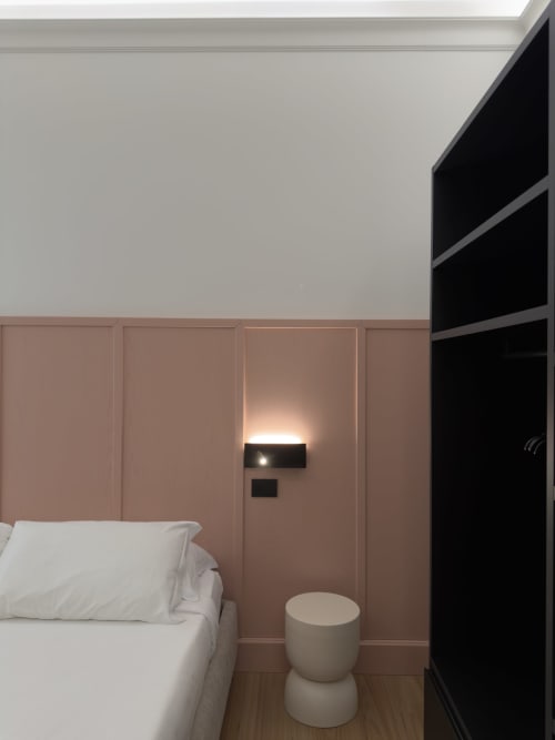 Camera da letto moderna a Maison Riviera con pareti rivestite di rosa, biancheria bianca, elegante guardaroba nero e design minimalista