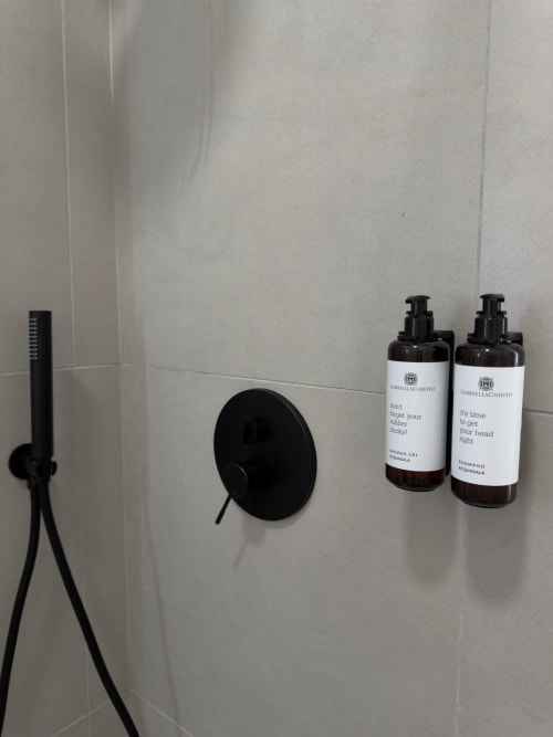 Lussuosi accessori da bagno a Maison Riviera con soffione nero, miscelatore e prodotti GabriellaChieffo a Reggio di