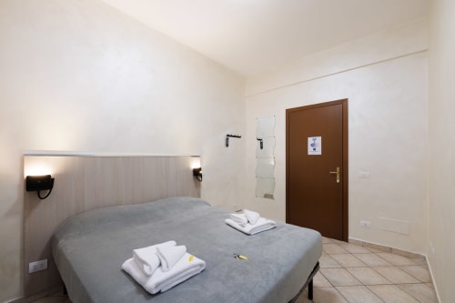 Camera moderna dell'hotel ViOletta a Lido di Ostia con letto matrimoniale, bagno privato e porta in legno