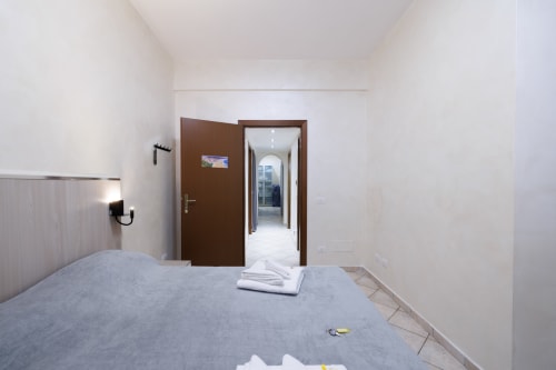 Camera moderna all'hotel ViOletta a Lido di Ostia con letto, porta marrone e pareti bianche minimaliste