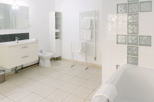 Modern bathroom in Appartement Carcassonne at Domaine de Bize, featuring vanity, toilet, heated towel rack, and decorative