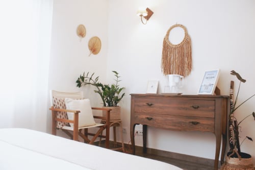 Quarto Sea Suite na Vila Vale Guest House com criado clássico em madeira, macramé na parede, plantas em vasos e design mid-century