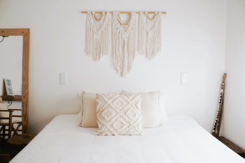 Quarto luminoso da Vila Vale Guest House com roupa de cama branca, painel de macramé e móveis em madeira em Charneca da