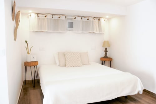 Quarto minimalista e iluminado na Vila Vale Guest House, com roupa de cama branca, mesas laterais em madeira e cortinas translúcidas em Charneca da