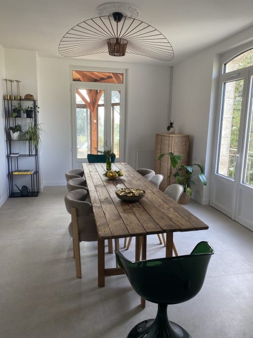 Salle à manger contemporaine du gîte Le Domaine les Olivoux avec table en bois, lampe suspendue design et vue sur le jardin