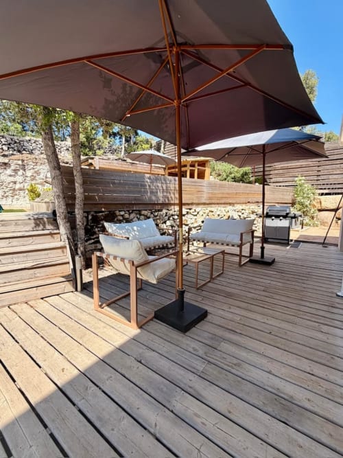 Patio ombragé aux Villas d'A Storia avec chaises longues et parasols donnant sur l'espace de détente extérieur