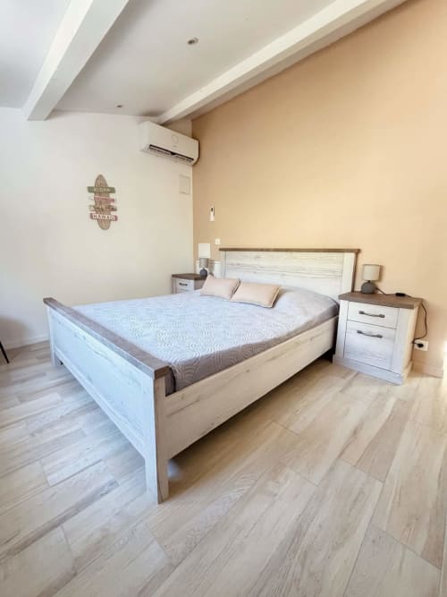 Chambre moderne avec lit queen-size, table de nuit en bois et climatisation à la Villa Amandine des Villas d'A Storia