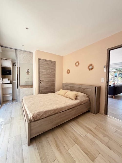 Chambre moderne à la Villa Amandine des Villas d'A Storia, Porto-Vecchio, avec lit en bois, murs pêche et salle de bains attenante