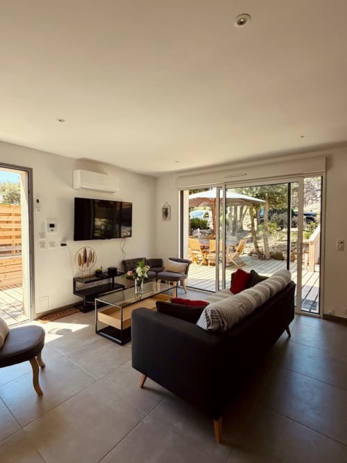 Élégant séjour de villa moderne aux Villas d'A Storia : mobilier noir, vue sur la terrasse et accès à la piscine